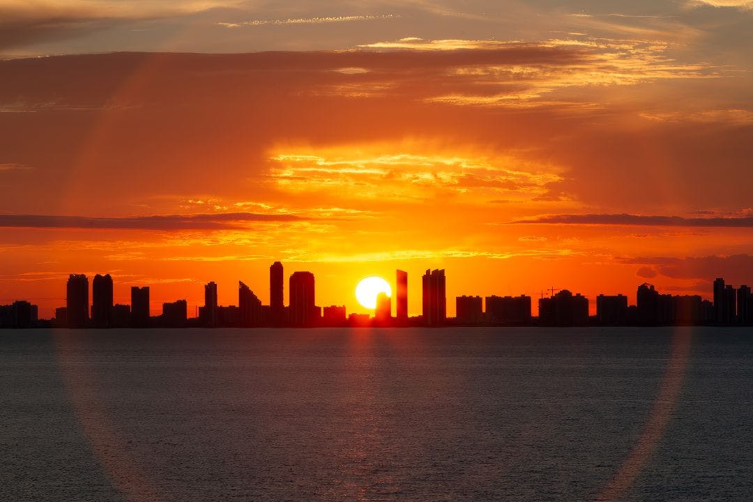 The sunset behind buildings on the Atlantic coastline in southern Florida Your Guide to Riding a Motorcycle in Southern Florida