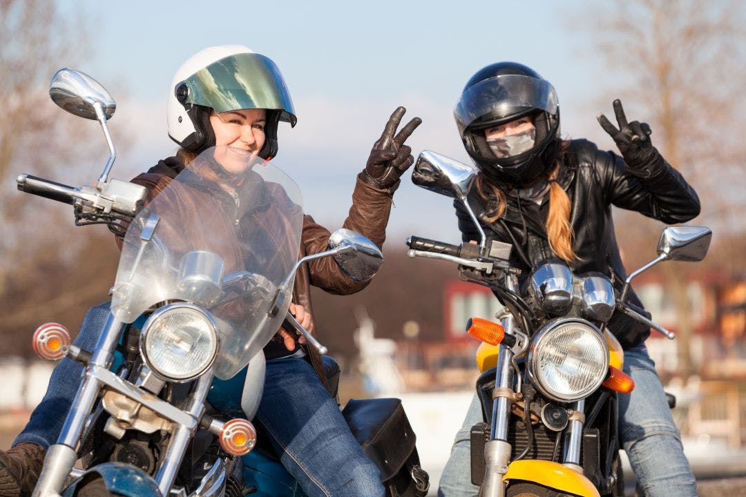 Victory signs in leather gloves from two laughing female bikers with street motorcycles Find Dallas Motorcycle Clubs & Attend Meetups