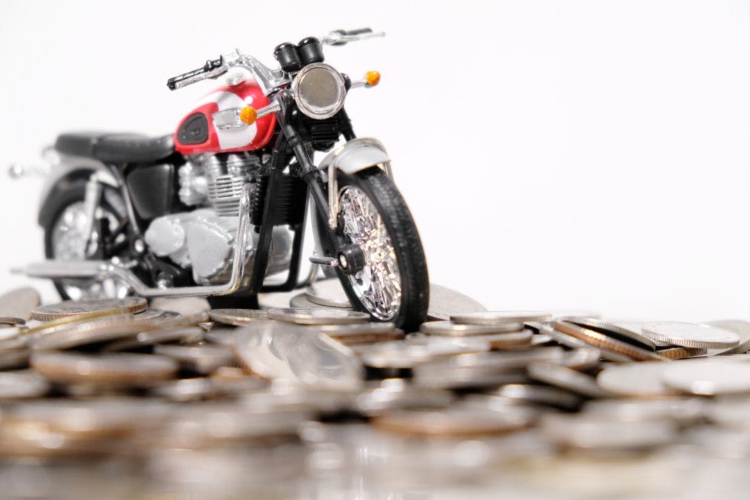 Modern classic motorcycle model on many of coins background, Finance concept How Much Do Motorcycle Rentals Cost in Fort Lauderdale?