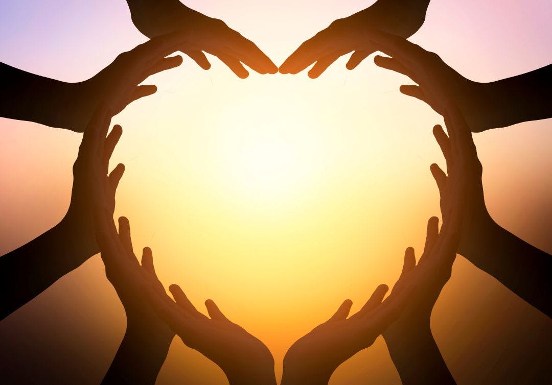hands in shape of heart on blurred background How to Meet New People in the Motorcycle Community