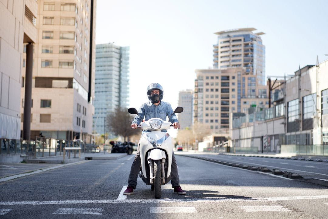 Wide shot of a young motorcyclist stopped at a traffic light Your Guide to Florida Motorcycle Laws