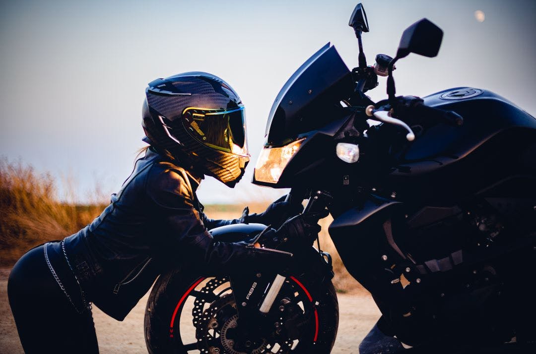 picture of a woman motorcycle rider looking face to face at her sport motorcycle best 500cc or less motorcycles