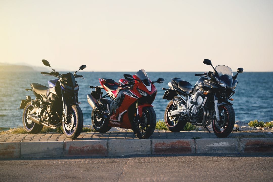 group of motorcycles parked in front of the ocean pros and cons of owning two plus bikes
