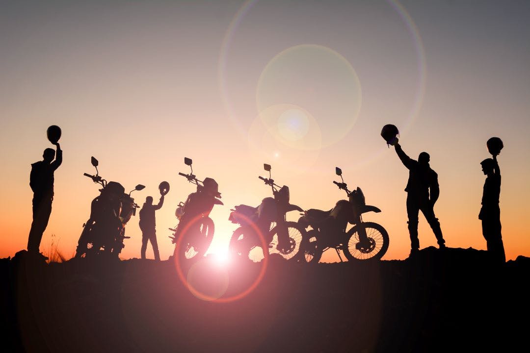 silhouette picture of a group of offroad motorcyclists at the top of a summit motorcycle clubs and meetups in tampa florida