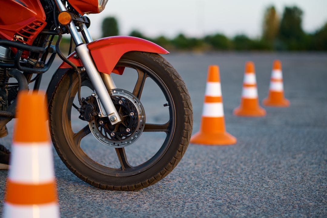 close up of motorcycle front wheel with cones in background Motorcycle Safety & Riding Classes in San Diego, California