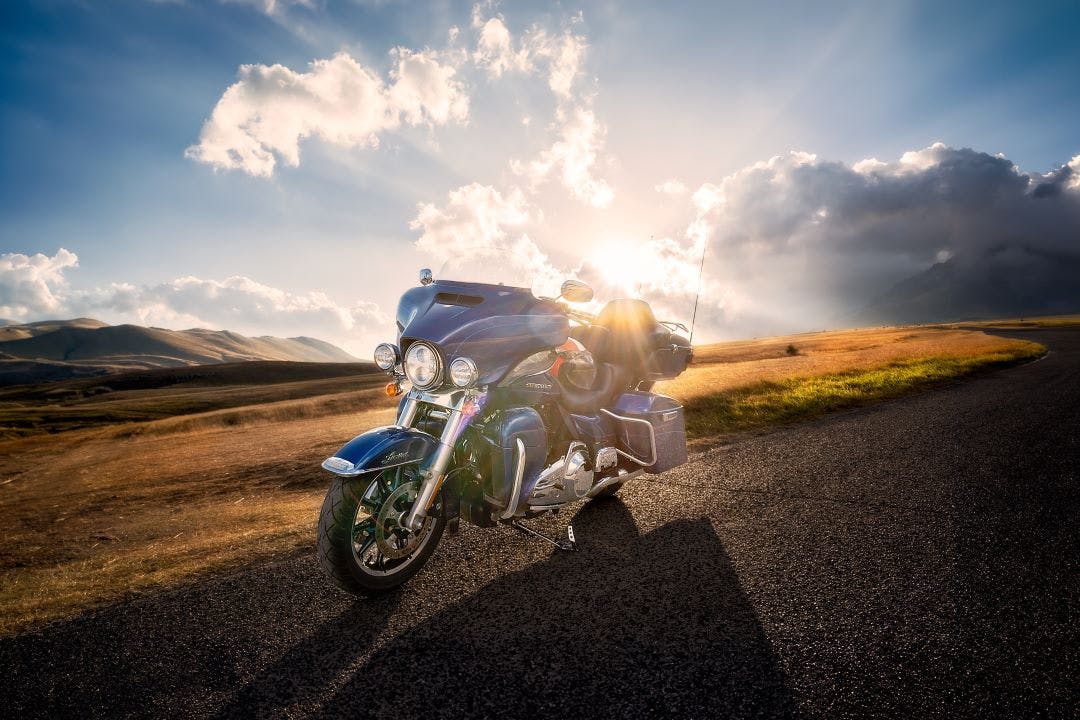 harley davidson road glide sitting on side of road with sunset behind Tips for Touring on a Harley-Davidson