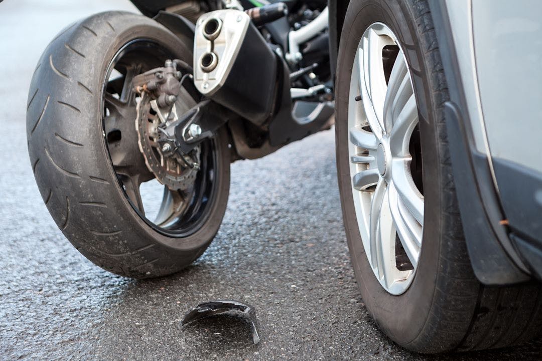 motorcycle accident close up view broken parts laying on ashpalt Here Are The Most Common Motorcycle Accidents & Causes