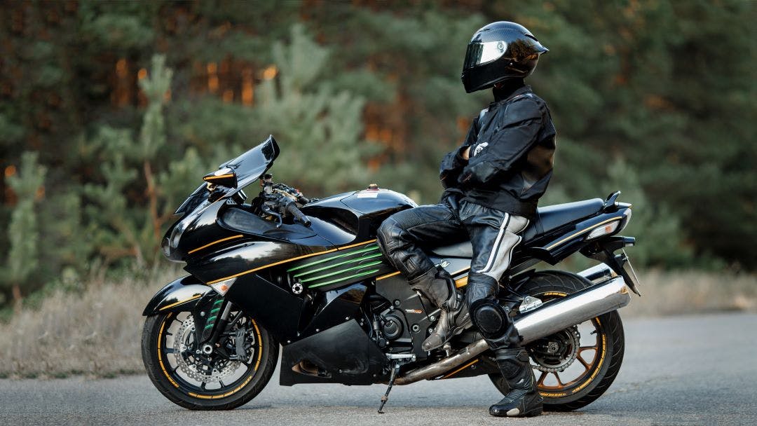 motorcycle rider sitting on fast sporty motorcycle with protective gear on Motorcycle Riding Tips