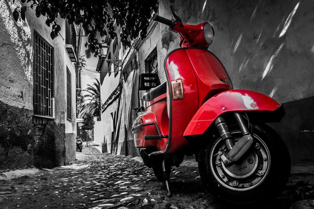 red vespa parked on street Can Vespas Go On the Highway? Vespa Riding FAQs
