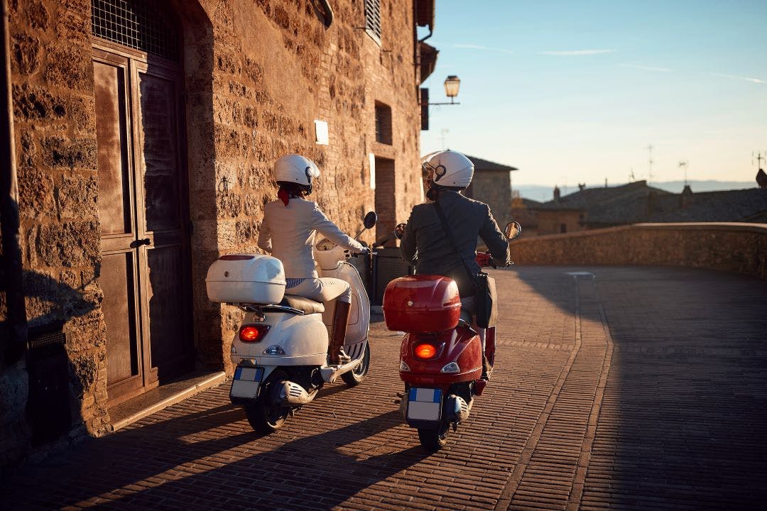 man and woman on vespa scooters Can Vespas Go On the Highway? Vespa Riding FAQs