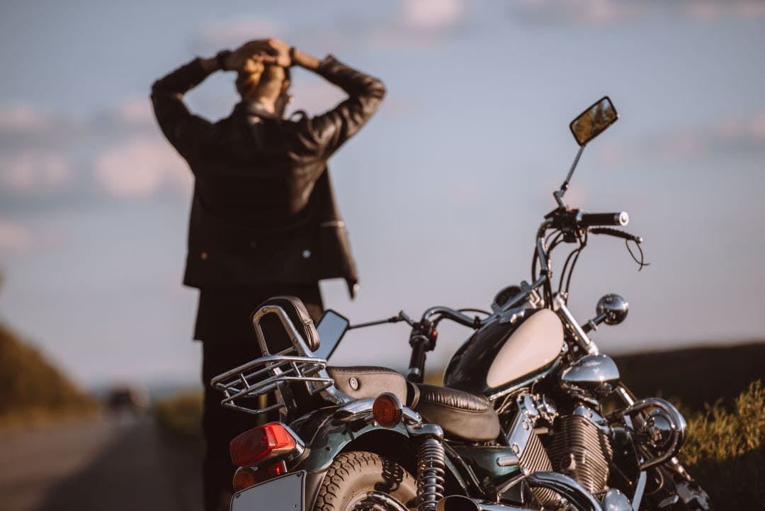 motorcycle riders on side of road with broke down bike Your Guide to Motorcycle Maintenance in Hot Weather