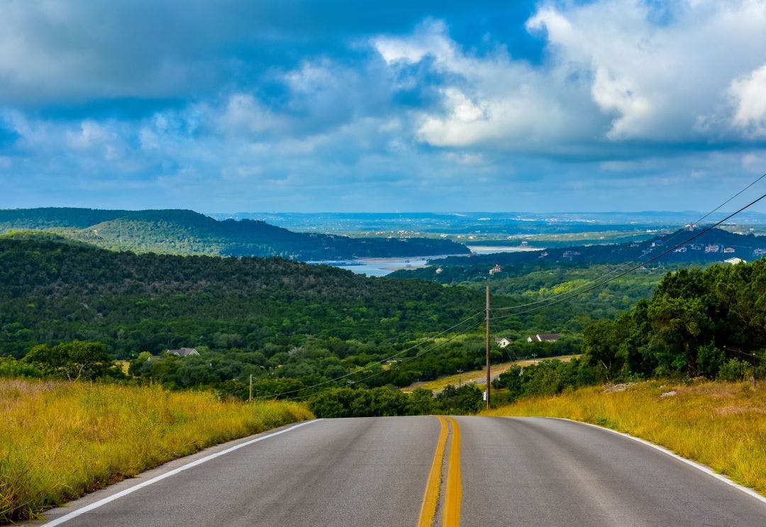 Open Road in the hill country underneath clouds and open sky Top Destinations for Motorcycle Rentals in 2024-2025