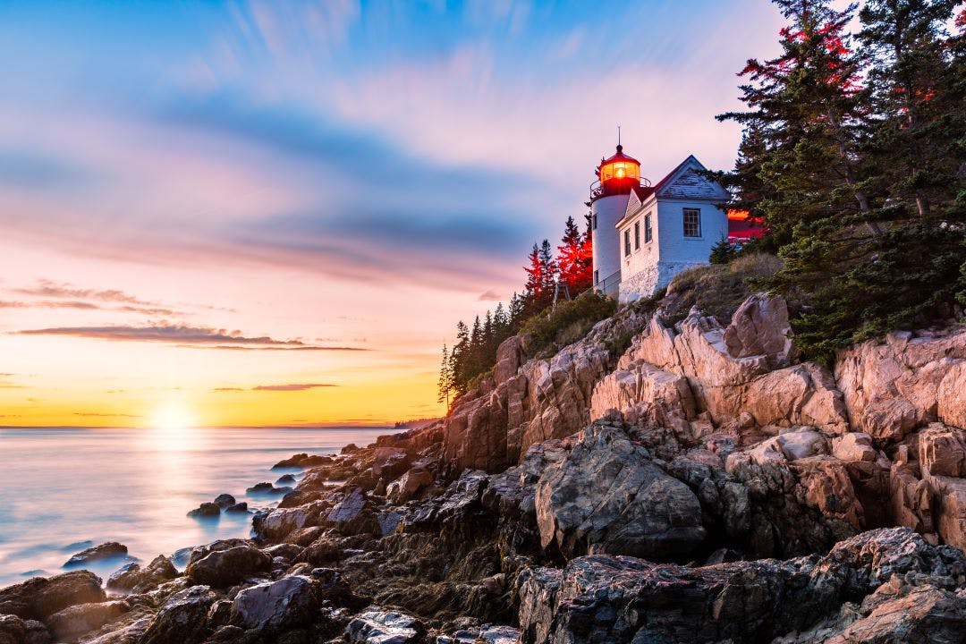 Bass Harbor Head lighthouse at sunset. Bass Harbor Head Light is a lighthouse located within Acadia National Park, Maine, marking the entrance to Bass Exploring the United State's National Parks by Motorcycle