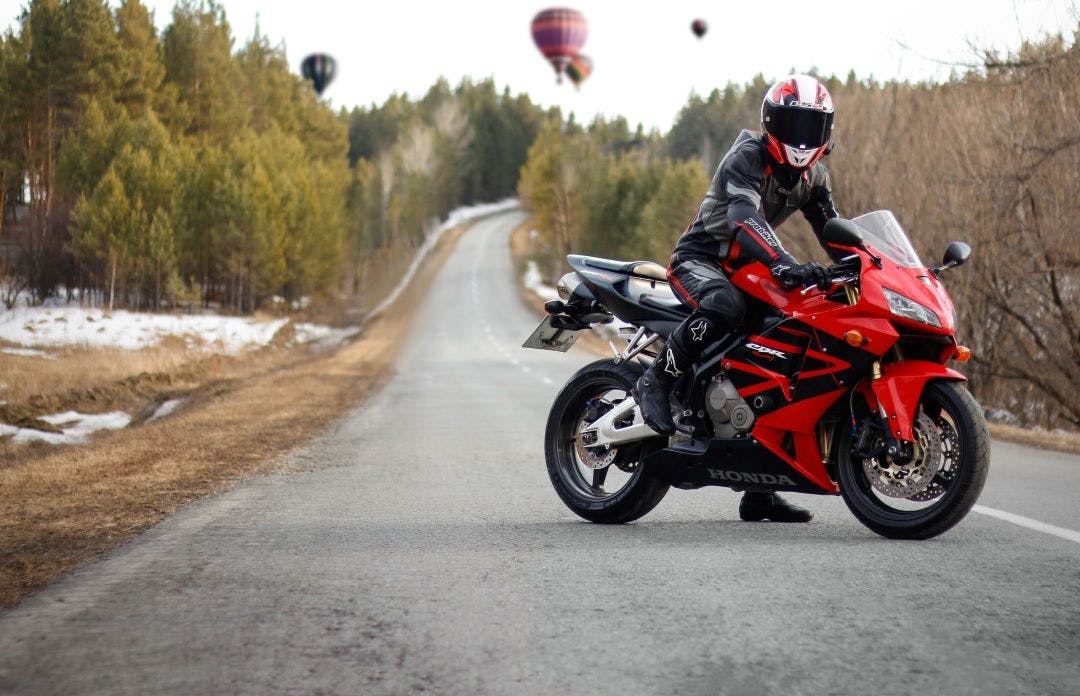 motorcyclist in full gear and helmet on a red and black Honda 2005 CBR 600 RR Popular Honda Motorcycles Available to Rent