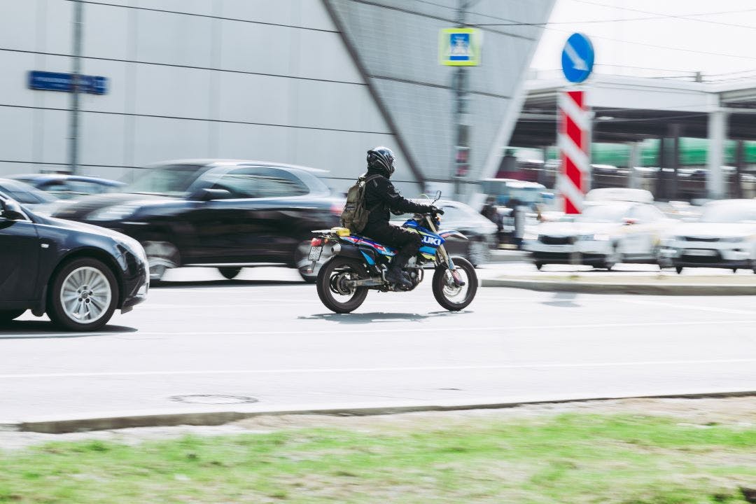 Motorcyclist on the Suzuki DR-Z400SM motorcycle driving on the city street What Exactly is a Dual Sport Bike