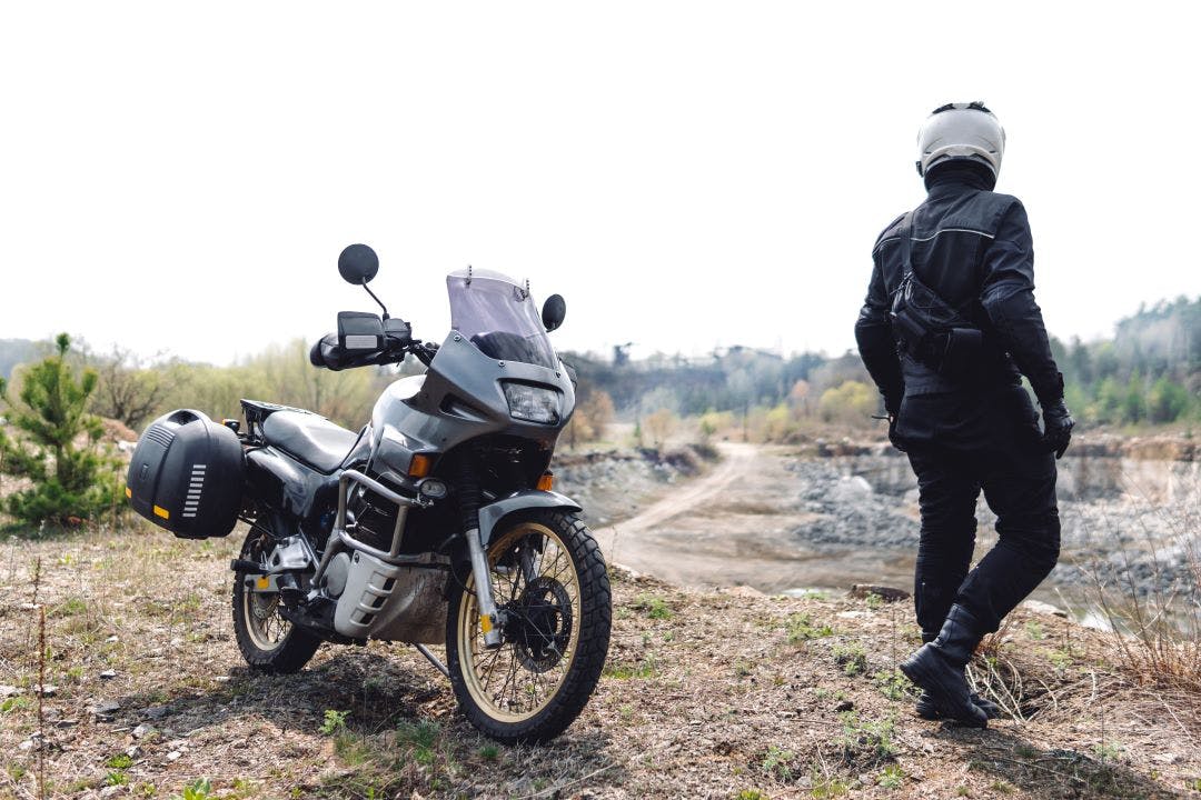 Motorcyclist man stands with his Adventure Motorbike. Off road. Dual Sport vs. Adventure Bikes - Let's Break It Down