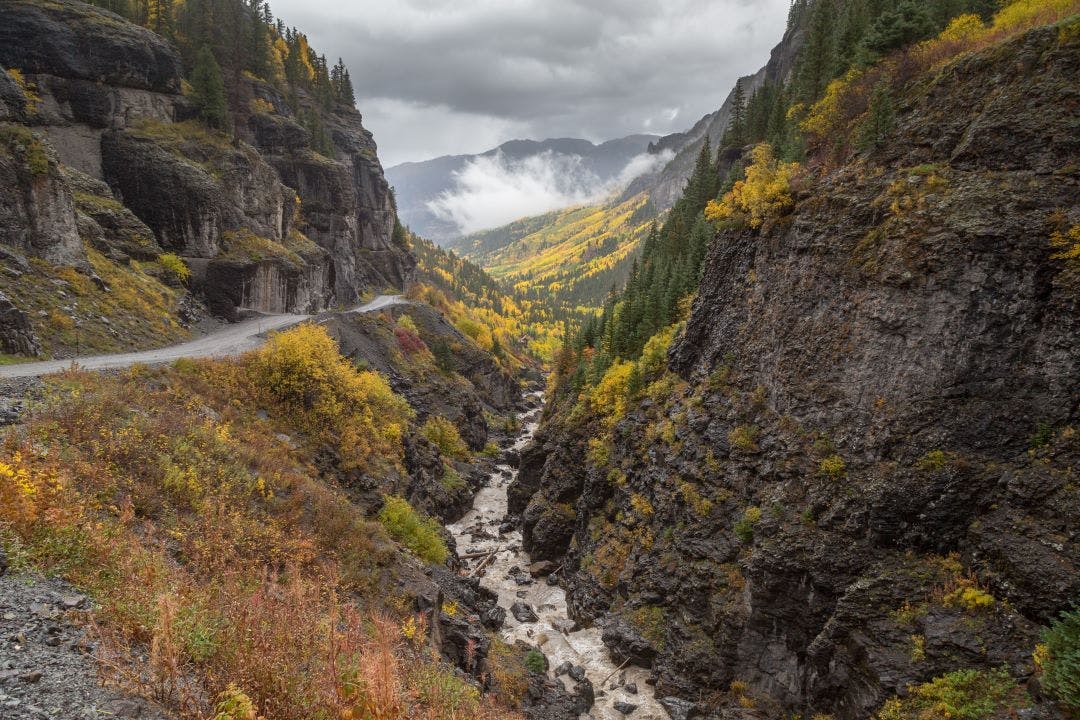 Colorado mountain rocky stream in fall colors aspens fir Best End of Summer Motorcycle Destinations to Plan ASAP