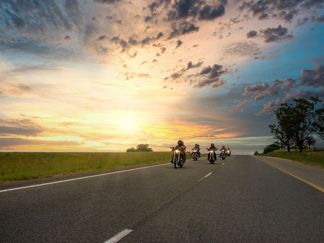 Small motorcycle group on road staggered formation Your Complete Guide to Group Riding: Etiquette, Signals, & More