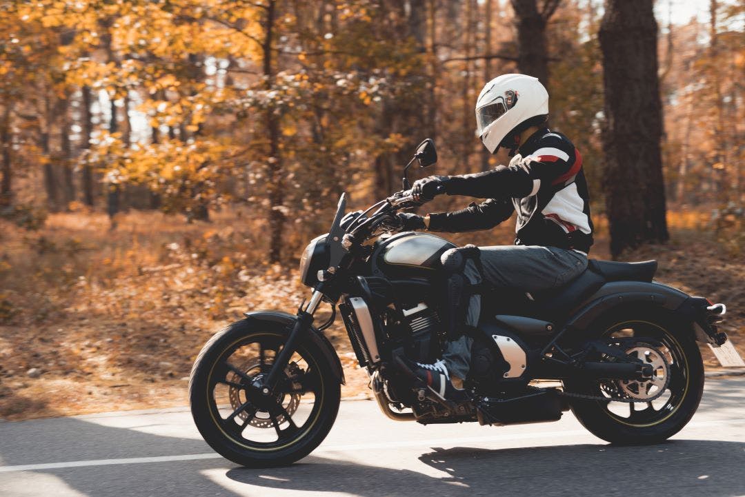 A young guy in a helmet is riding on a forest road on an electric motorcycle The Benefits of Electric Motorcycles (And Potential Cons)