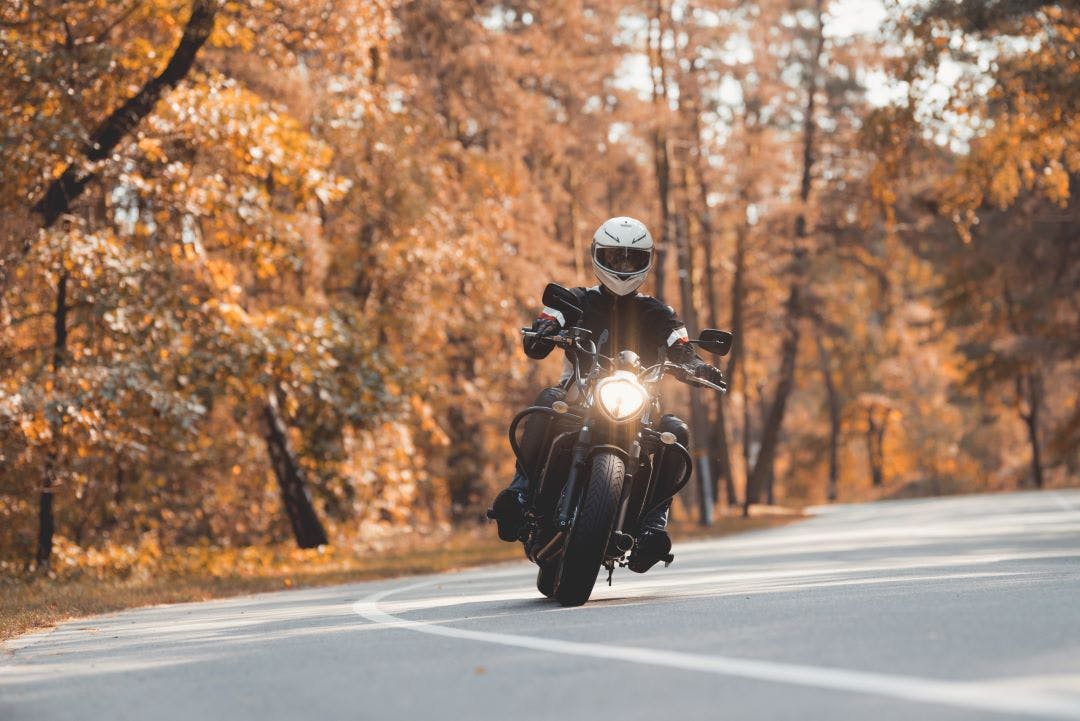 A young guy in a helmet is riding on a forest road on an electric motorcycle 2 The Benefits of Electric Motorcycles (And Potential Cons)