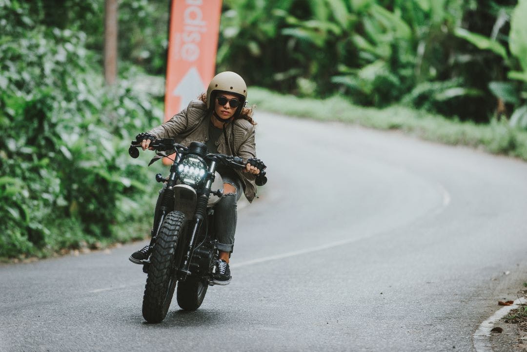 Beautiful girl having fun driving her custom cafe racer motorcycle Badass Women's Motorcycle Clubs & Collectives