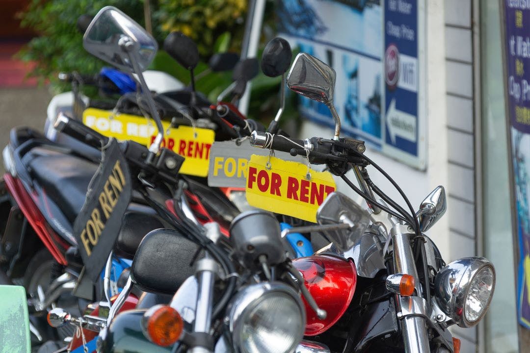 For Rent sign hanging on motorcycle handlebars Why Are Motorcycle Rentals SO Expensive?