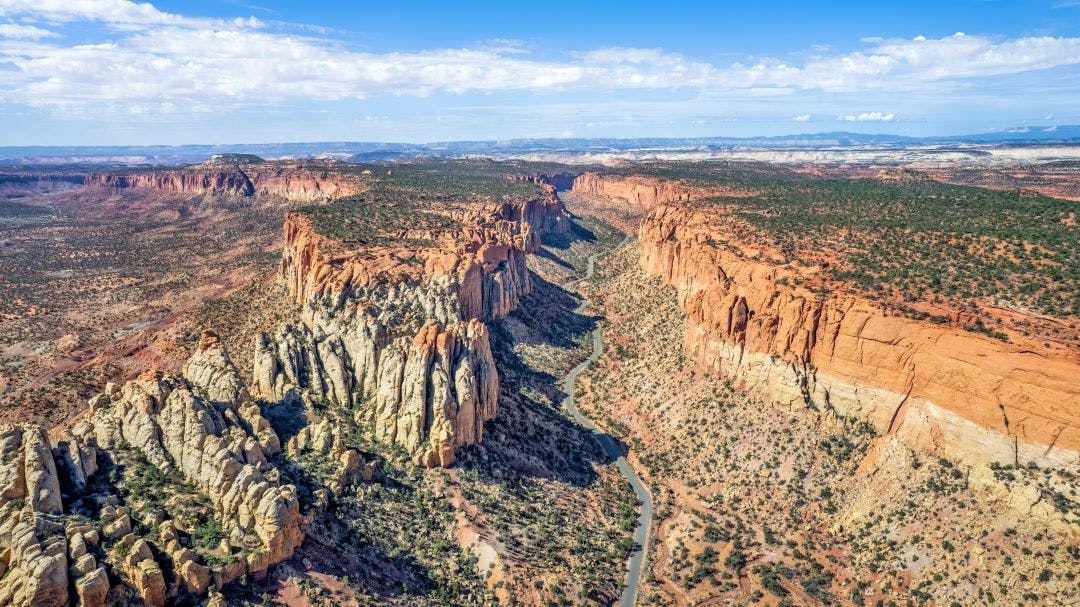 The East Burr Trail Road winding through the red rock walls of Long Canyon, Utah, USA Best of Utah Motorcycle Rides to Explore Now