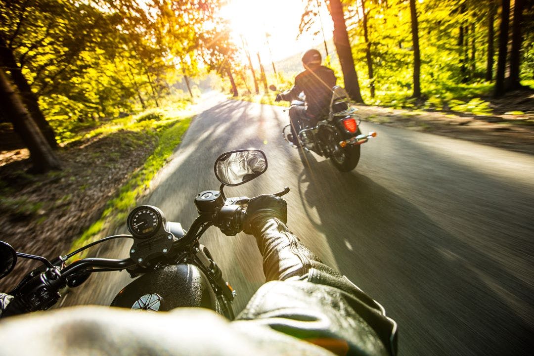 two motorcycle riders on wooded road Beginner-Friendly Motorcycle Tours in the United States