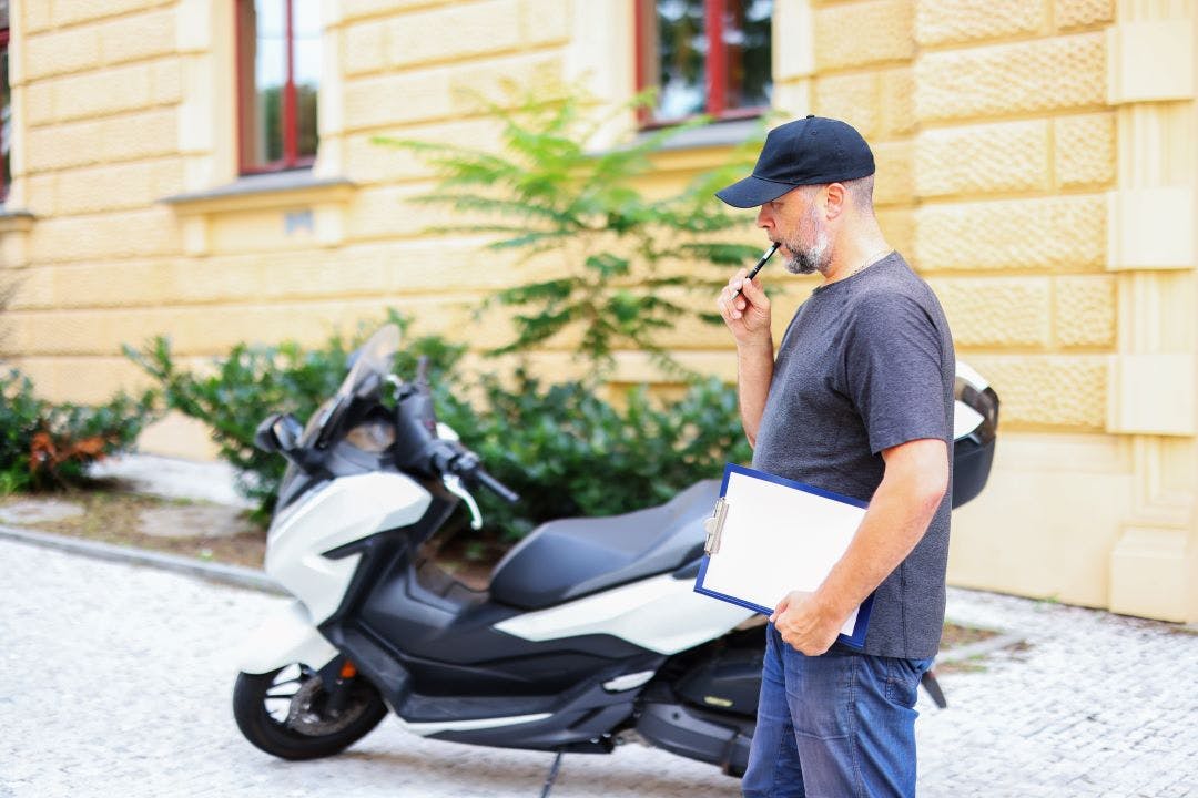 a man checks a motorcycle motorcycle rental How to Write a Description for Selling (or Renting) Your Bike