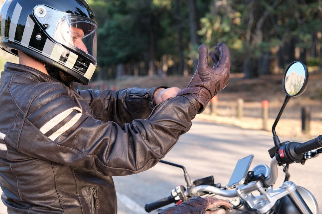 A biker puts on gloves before riding on motorbike Motorcycle Gear Rentals: Should You, Can You?