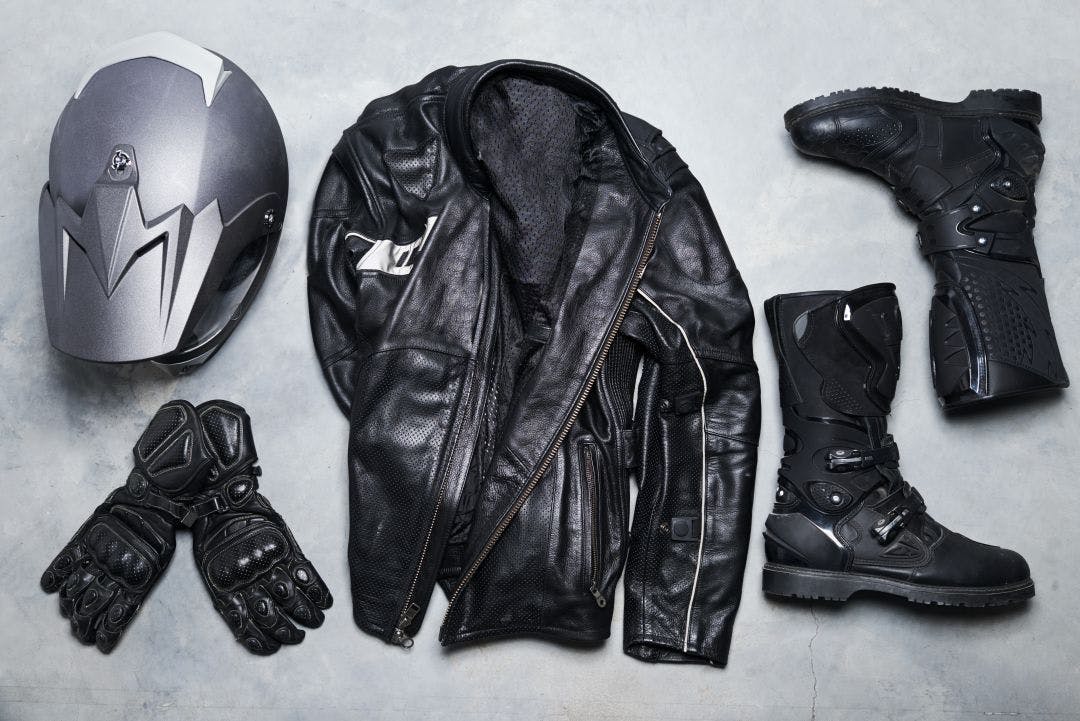 High angle shot of biker gear against a gray background Motorcycle Gear Rentals: Should You, Can You?