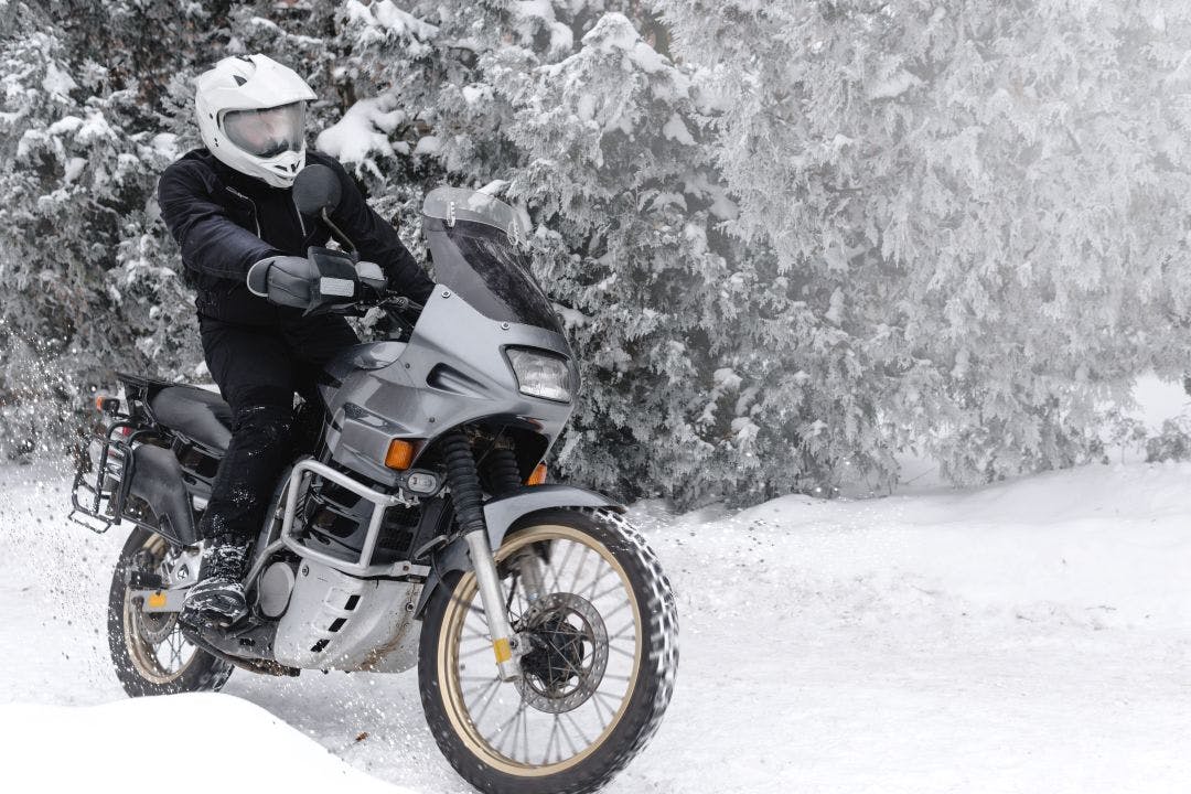 Rider man in action on adventure motorcycle. Winter fun. snowy day. ride on snow road. off road. dual sport travel tour, active life style concept. winter clothes, equipment Riding a Motorcycle in the Winter: Can You? Should You?