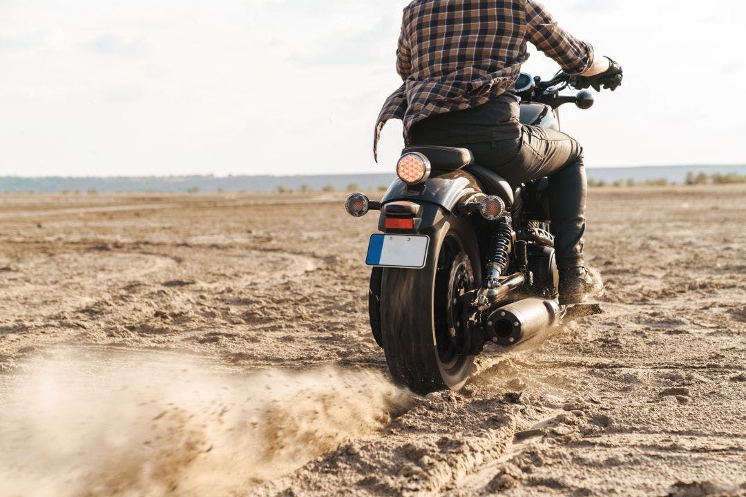 Man biker on bike outdoors at the desert field Prepping for Desert Motorcycle Riding