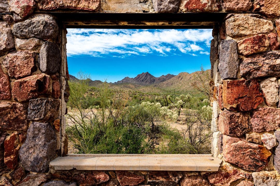 Looking through the window at the picturesque desert landscape from the ruins of a stone house on the Bowen Trail in Tucson Arizona Motorcycle Route To Gates Pass from Tucson