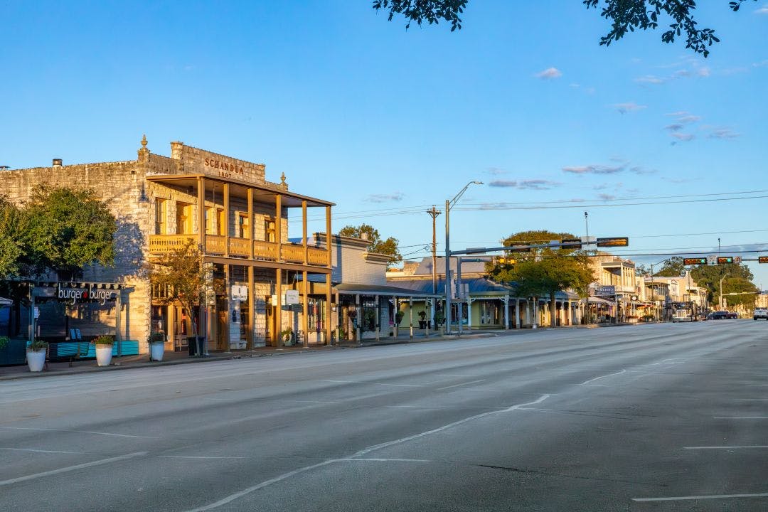 The Main Street in Frederiksburg, Texas, also known as The Magic Mile, with retail stores and people walking Is San Antonio, Texas, a Good Place to Ride Motorcycles?