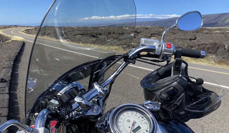 Picture of Motorcycle on the side of a deserted road in Hawaii with a beautiful open view for miles