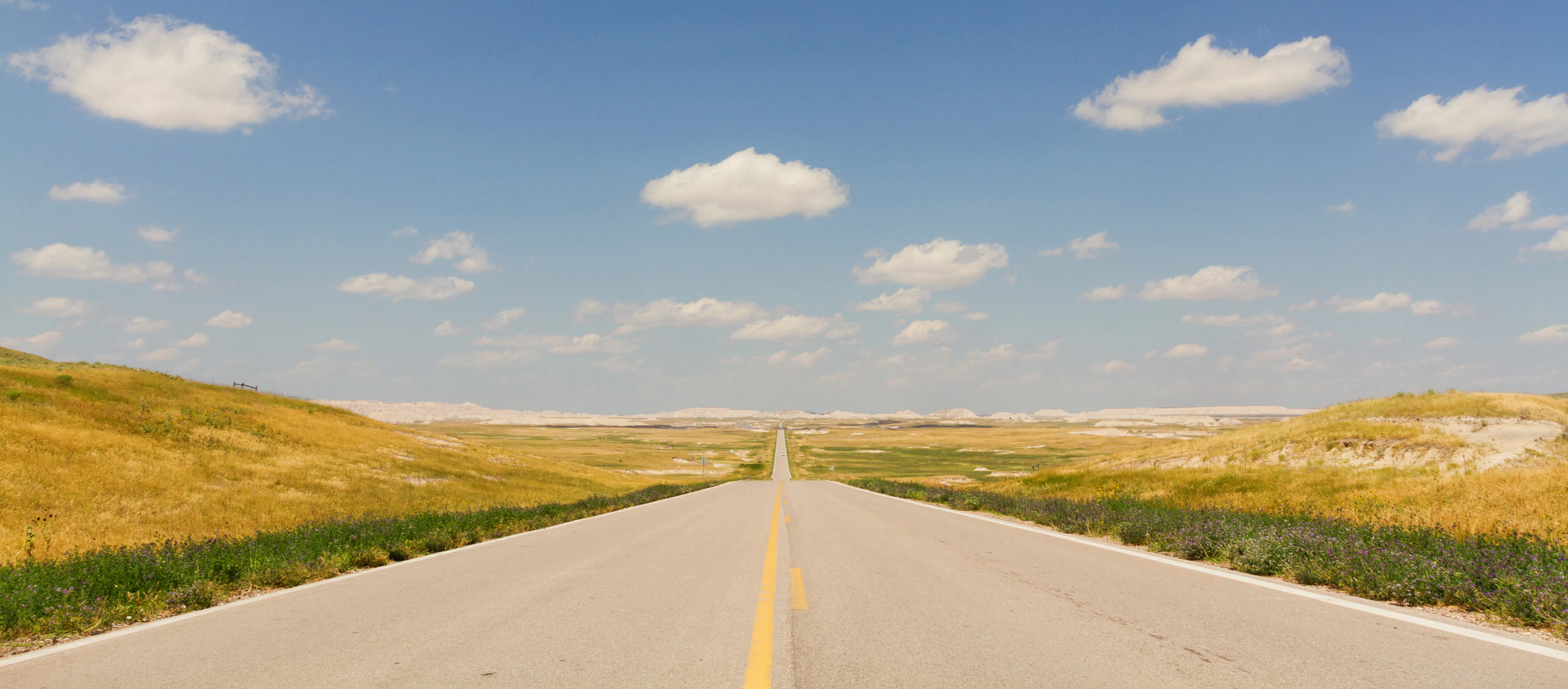 Conduciendo en un hermoso día soleado por una carretera recta y bien mantenida en North Dakota