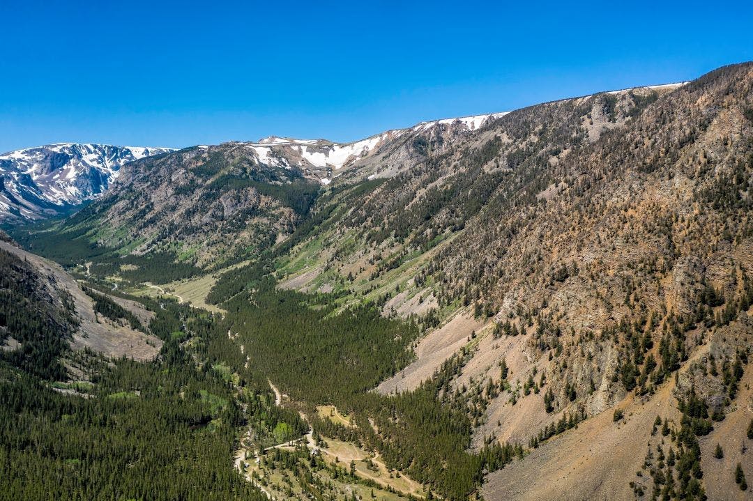 Aerial view of valley located in high Montana mountains near iconic town Red Lodge. Snow on the peak tops. Beartooth Rally 2025 Guide: Red Lodge, Montana