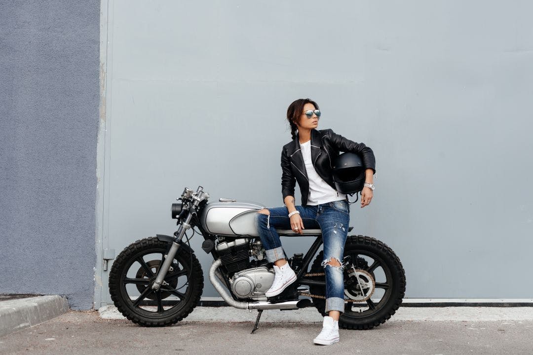 Biker woman in leather jacket on motorcycle Motorcycle Rentals & the Gender Gap – Improving Equity