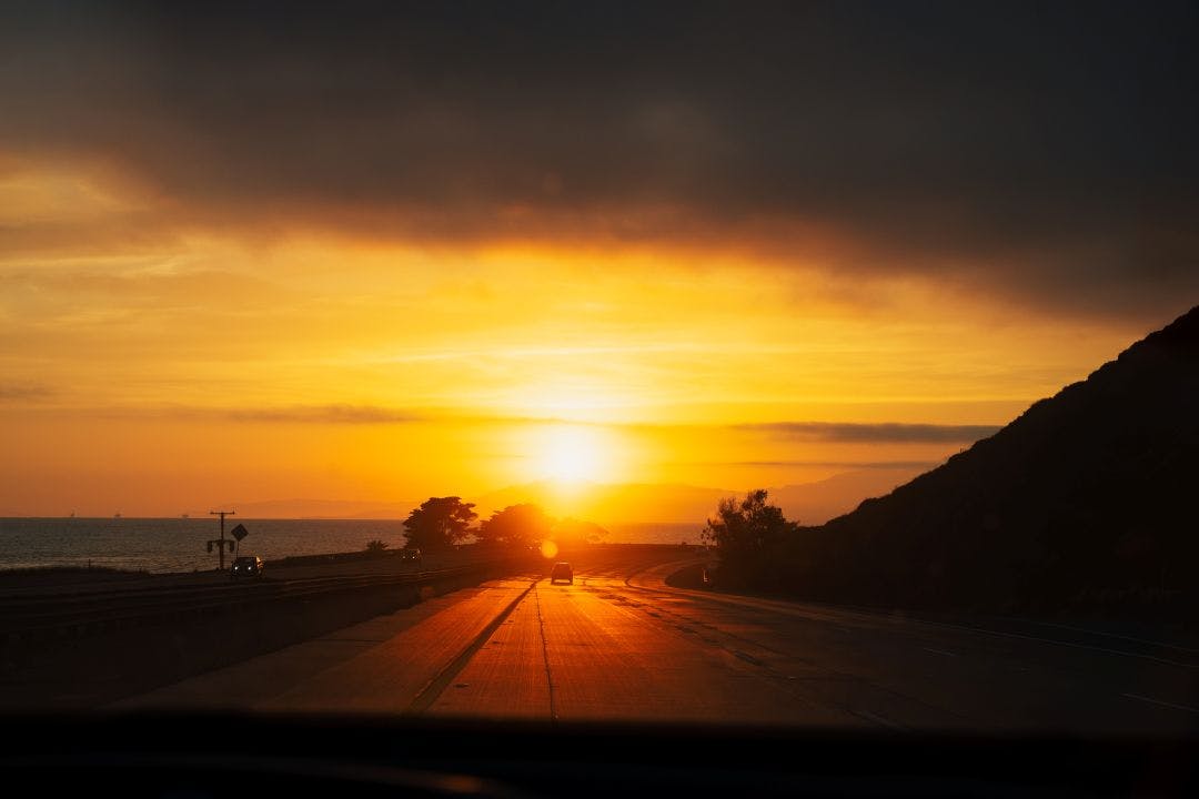 Stunning golden orange sunset on highway 101 California with few cars ocean and mountains. Road trip west coast USA Top Motorcycle Routes in the USA for Scenic Coastal Views