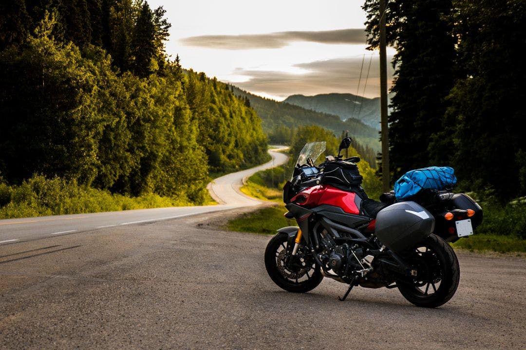 motorcycle parked on side of road for a break while on long road trip How to Plan & Prepare for Longer Distance Motorcycle Trips