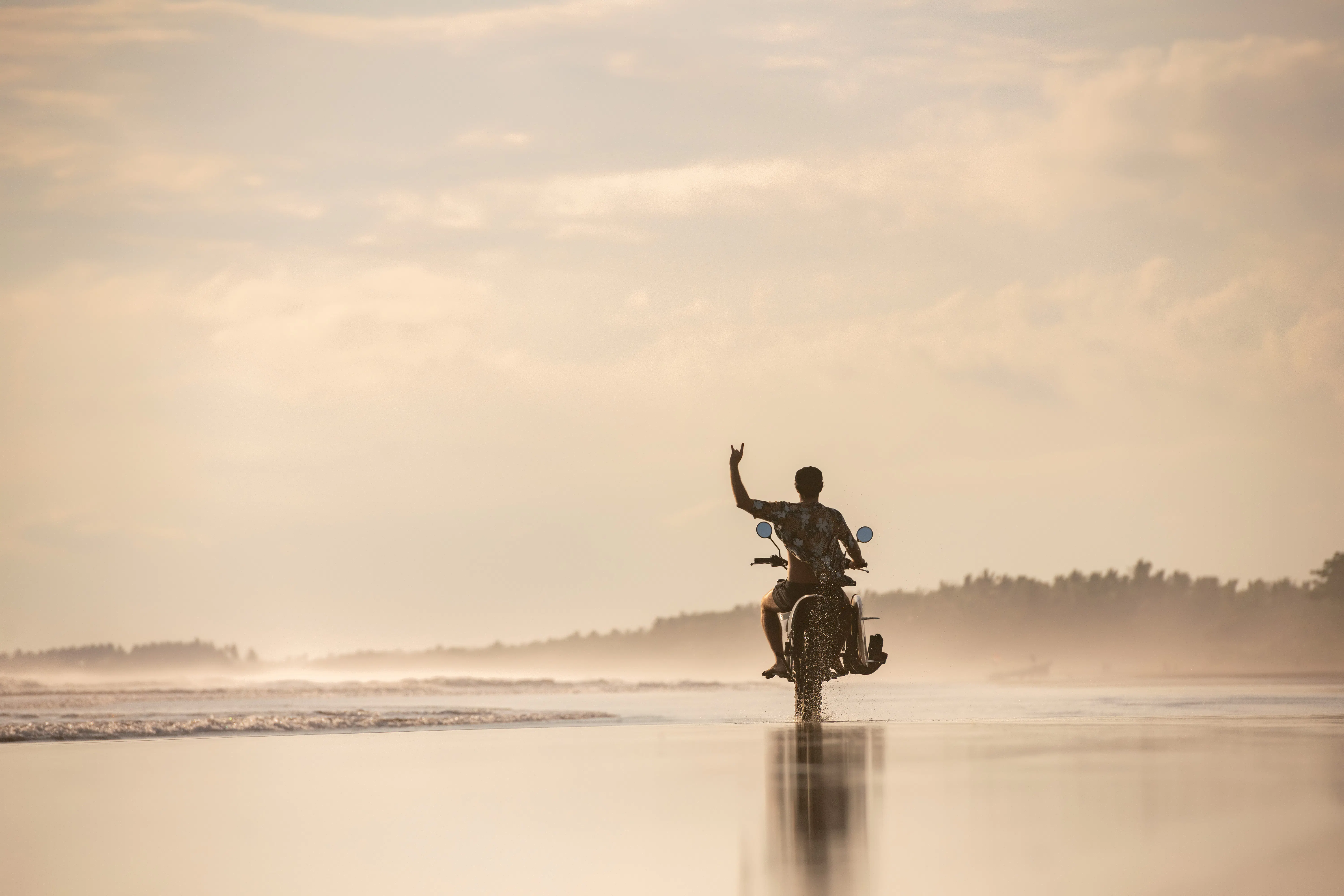 image of biker on a motorcycle on the beach - compare hawaii motorcycle insurance quotes on Riders Share