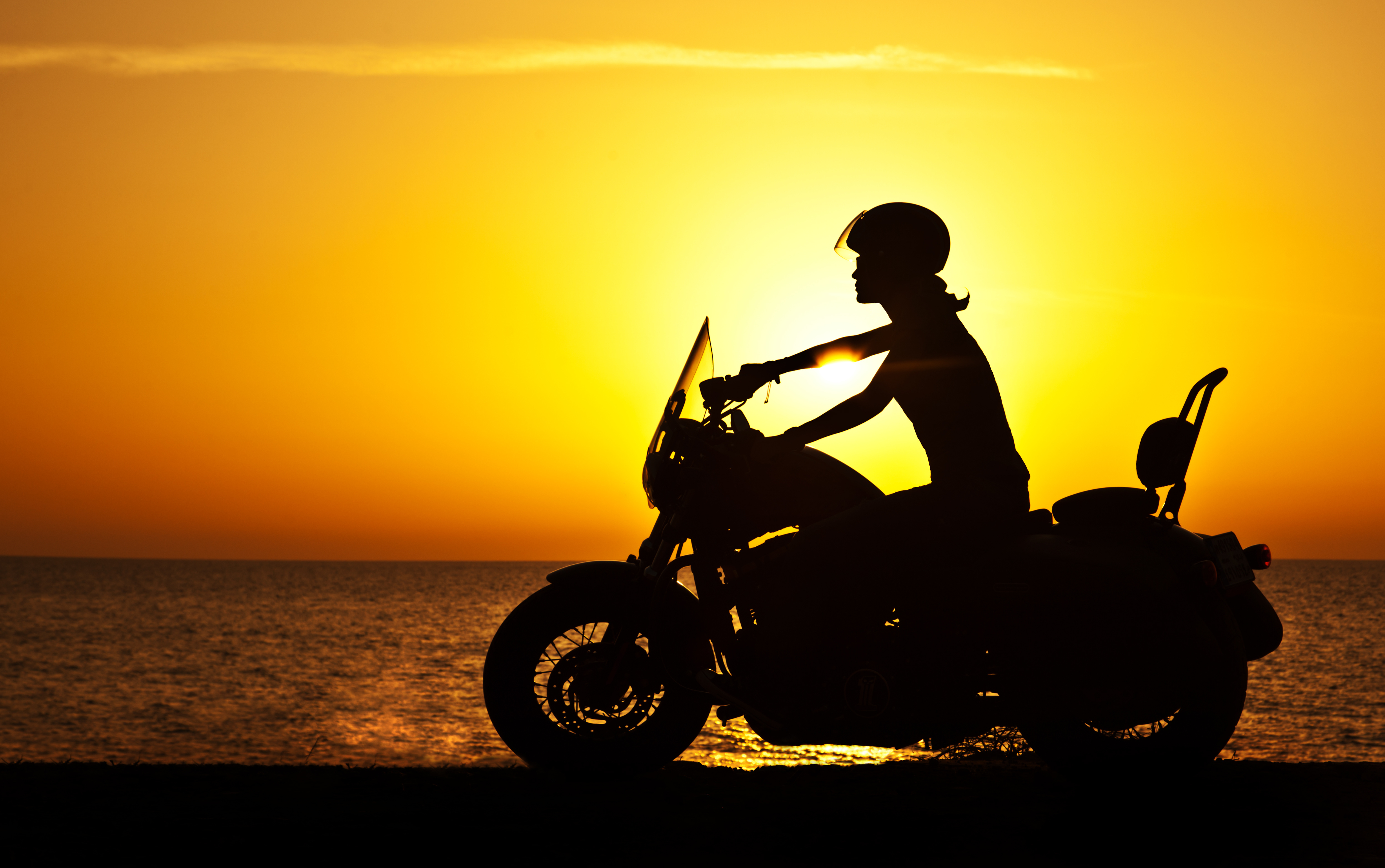 image of rider on a motorcycle on the beach - compare hawaii motorcycle insurance quotes on Riders Share