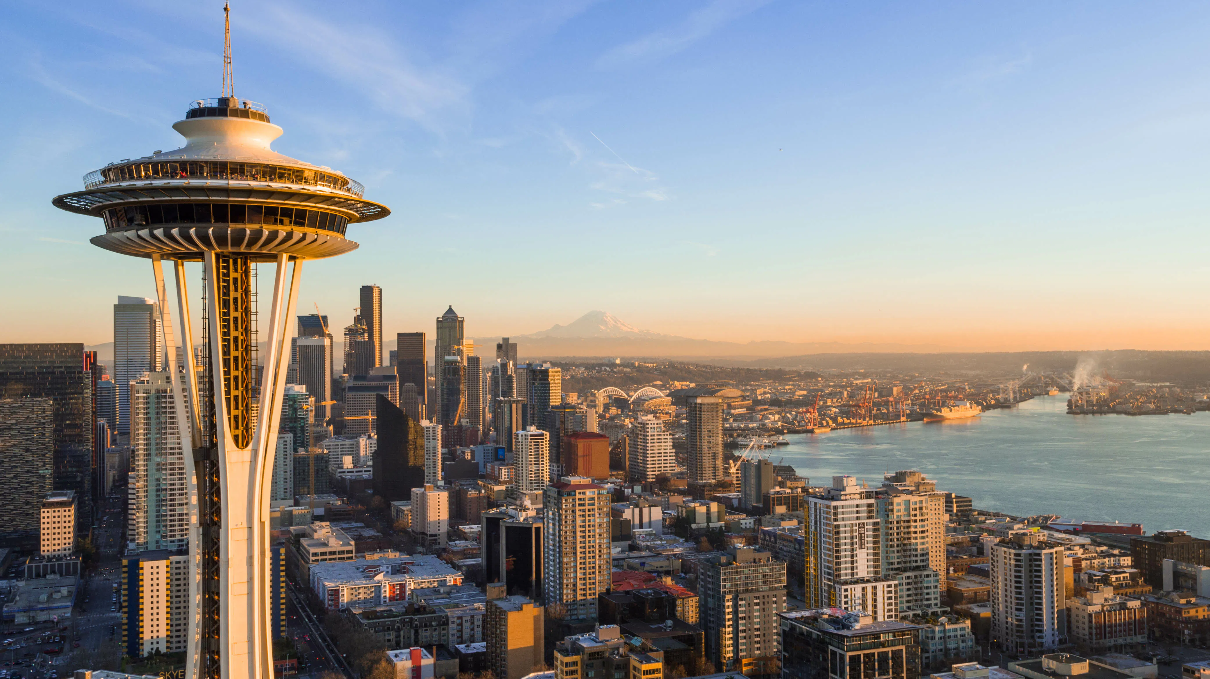 Pike Place Market sign and Seattle waterfront with downtown skyline behind