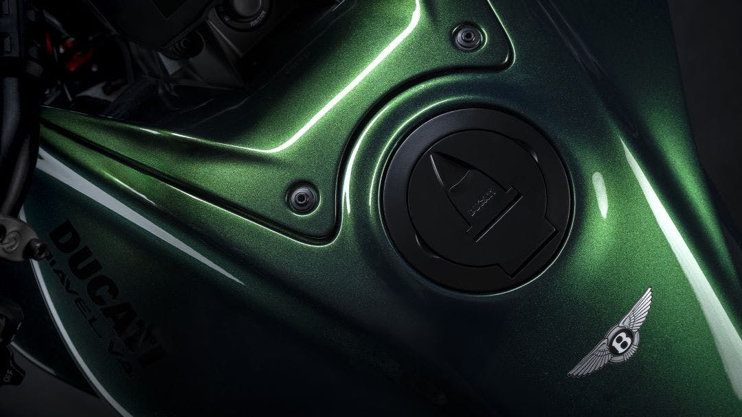 close up of the gas tank with bentley signature on the new 2024 ducati diavel for bentley motorcycle guide and specifications for the new 2024 ducati diavel for bentley