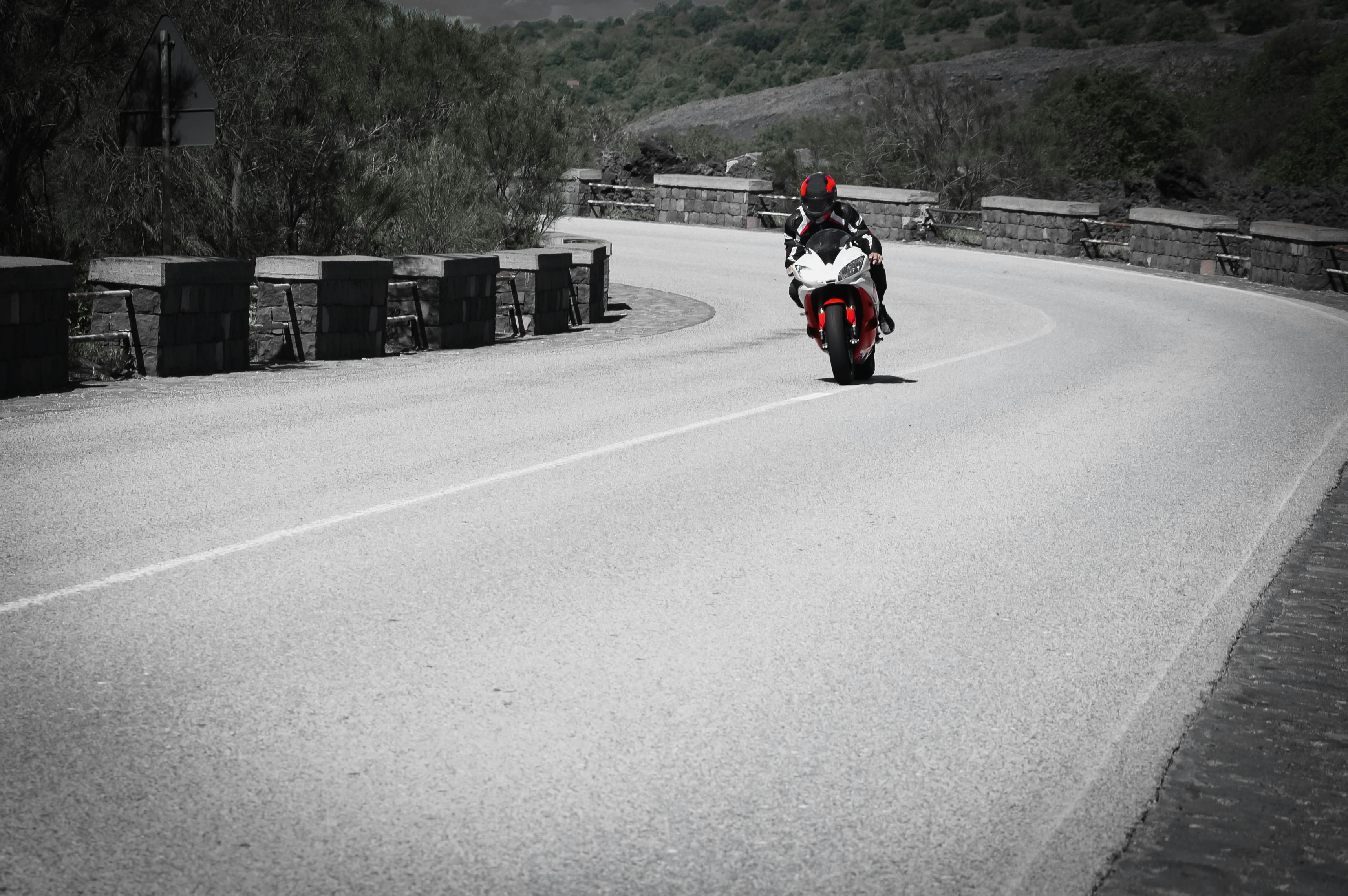 motorcycle rider with helmet riding a sport bike on a scenic curvy road