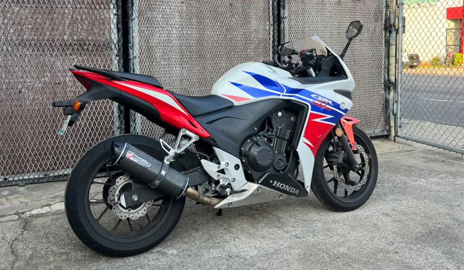 Foto de um blue red white 2014 Honda CPR500R ABS estacionado na frente de uma cerca em uma cidade no Hawaii