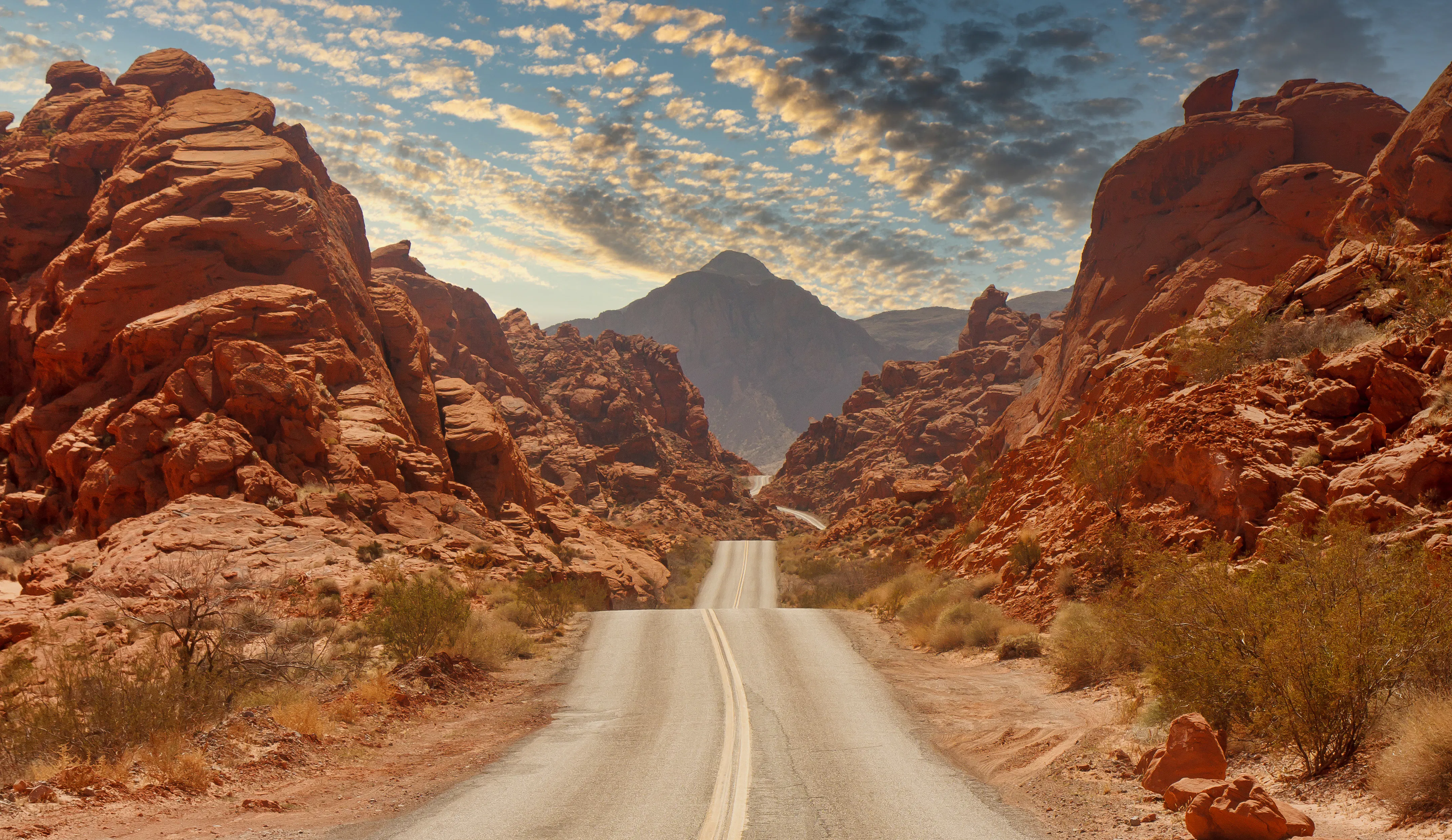 Conducir por una autopista que atraviesa cañones de roca roja en Nevada