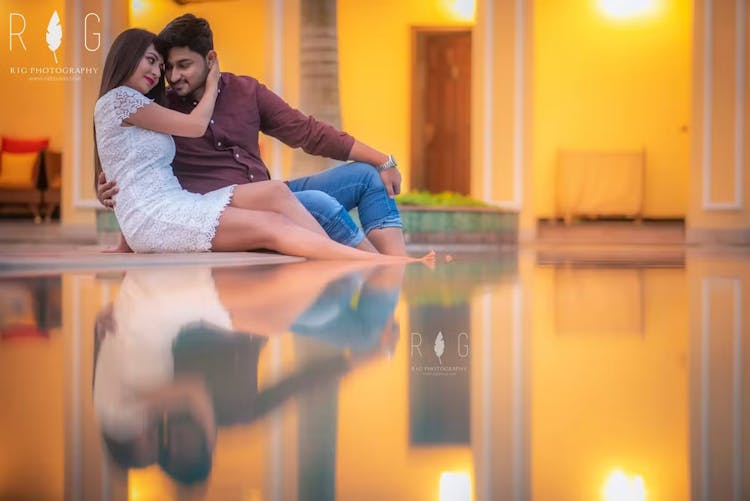 Couple posing by the side of a swimming pool for wedding photography before wedding