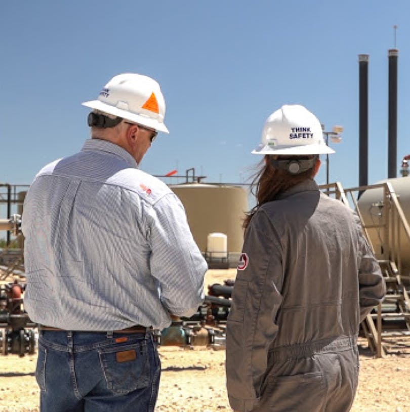 Oil & gas workers inspect tanks.